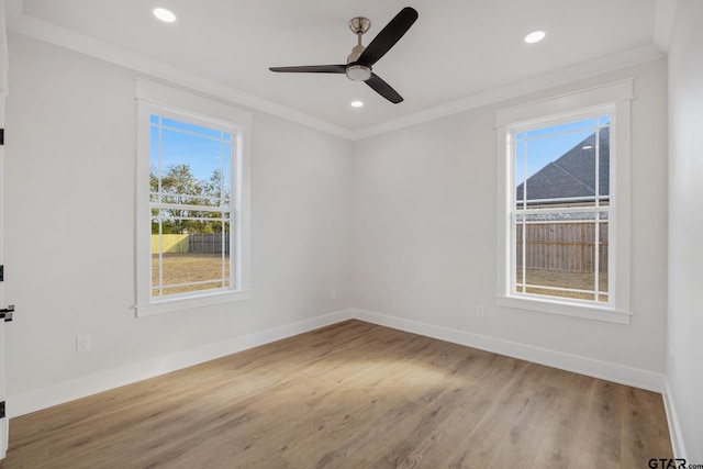 unfurnished room featuring ceiling fan, light hardwood / wood-style floors, ornamental molding, and plenty of natural light