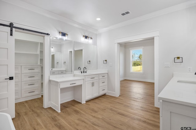 bathroom featuring vanity, hardwood / wood-style floors, and crown molding