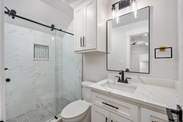 bathroom with toilet, vanity, and a shower with shower door