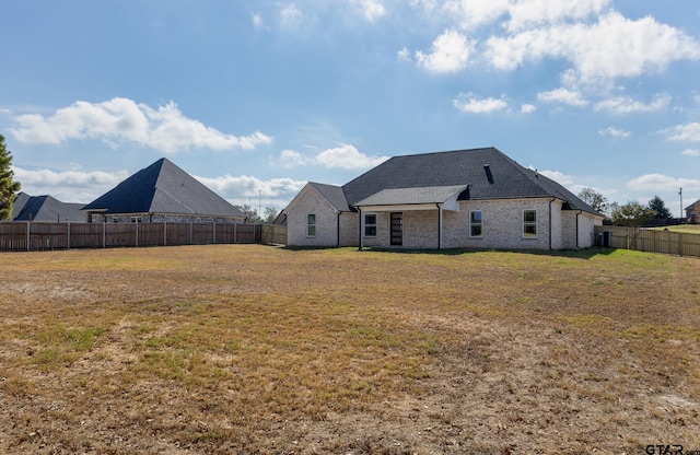 rear view of house featuring a lawn