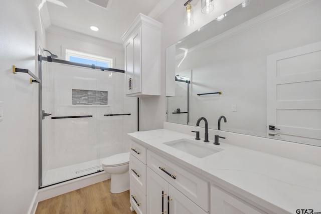 bathroom featuring toilet, hardwood / wood-style flooring, ornamental molding, an enclosed shower, and vanity