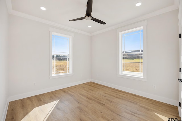 empty room with plenty of natural light, light hardwood / wood-style floors, and crown molding