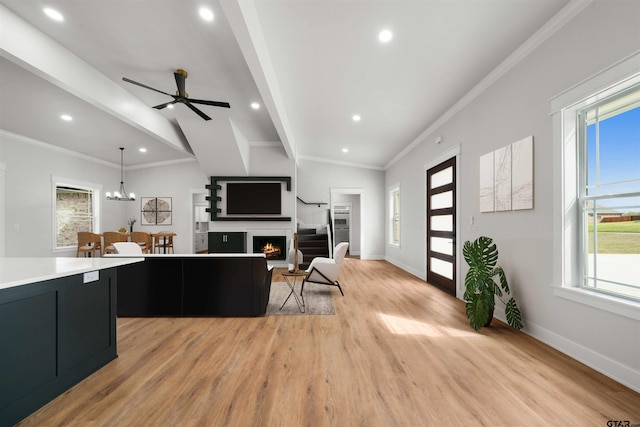 kitchen featuring lofted ceiling with beams, ornamental molding, light hardwood / wood-style flooring, pendant lighting, and ceiling fan with notable chandelier