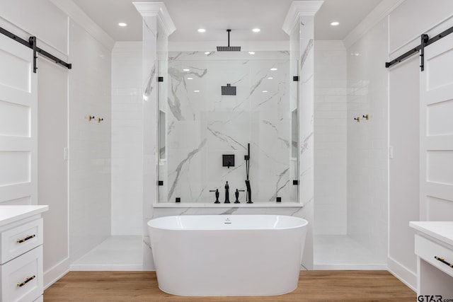 bathroom featuring wood-type flooring, plus walk in shower, and vanity