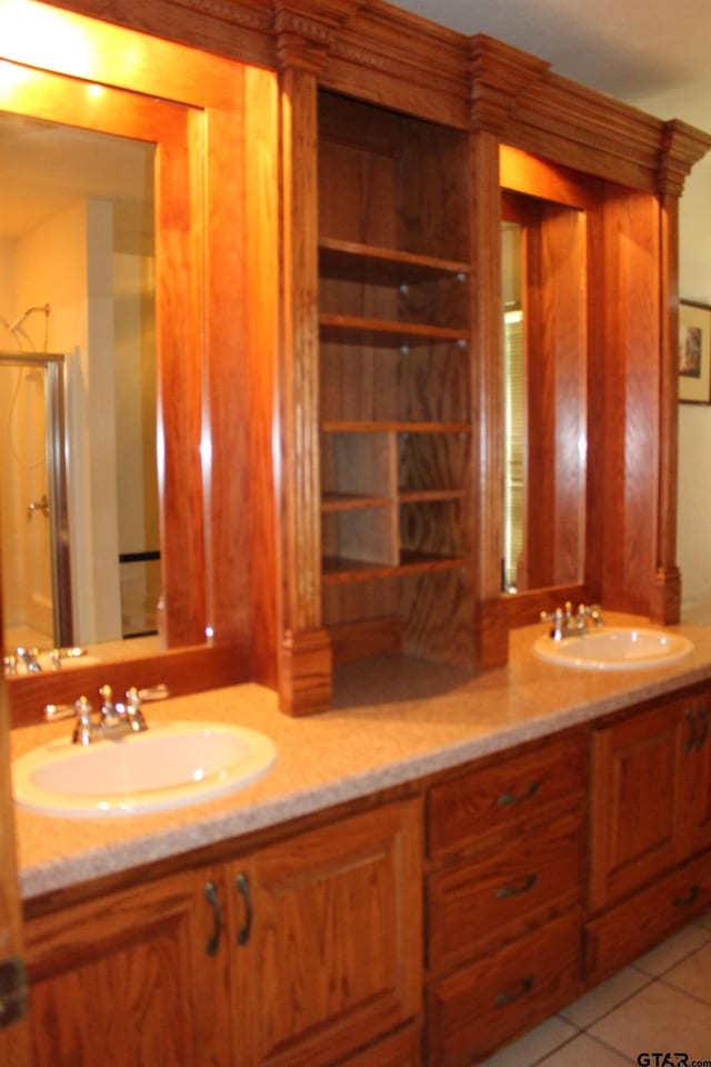 bathroom with an enclosed shower, vanity, and tile patterned floors