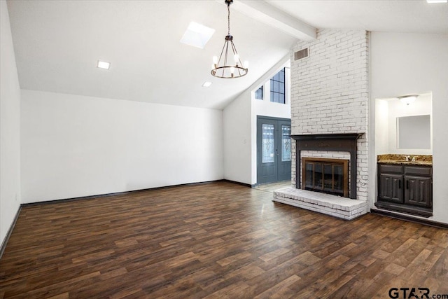 unfurnished living room featuring dark wood-style flooring, visible vents, a chandelier, high vaulted ceiling, and a fireplace