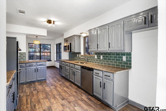 kitchen featuring decorative backsplash, gray cabinetry, a sink, and appliances with stainless steel finishes