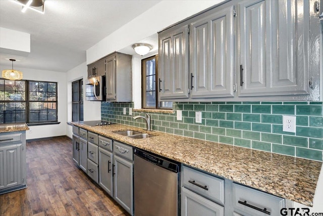 kitchen featuring a sink, gray cabinets, backsplash, baseboards, and appliances with stainless steel finishes