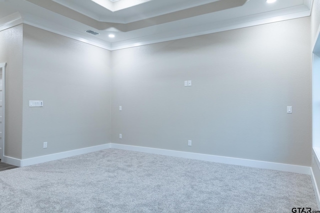 carpeted spare room featuring ornamental molding and a tray ceiling