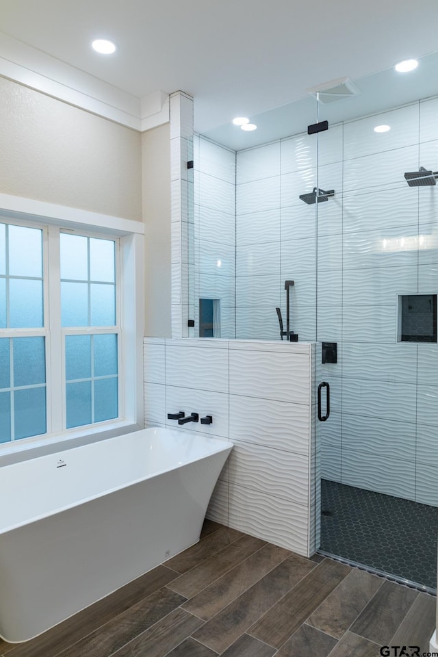 bathroom featuring shower with separate bathtub