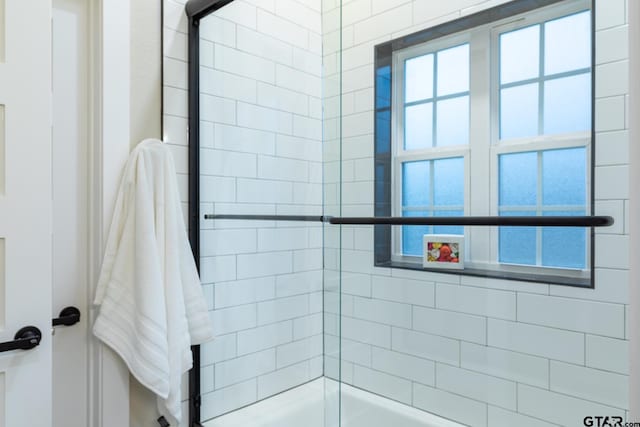 bathroom with bath / shower combo with glass door