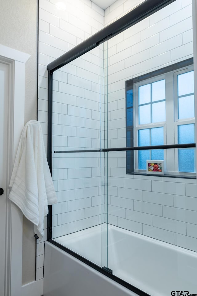 bathroom featuring combined bath / shower with glass door