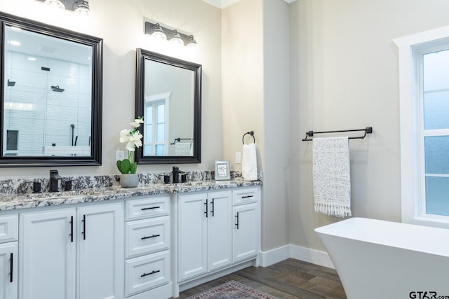 bathroom with plus walk in shower, vanity, and wood-type flooring