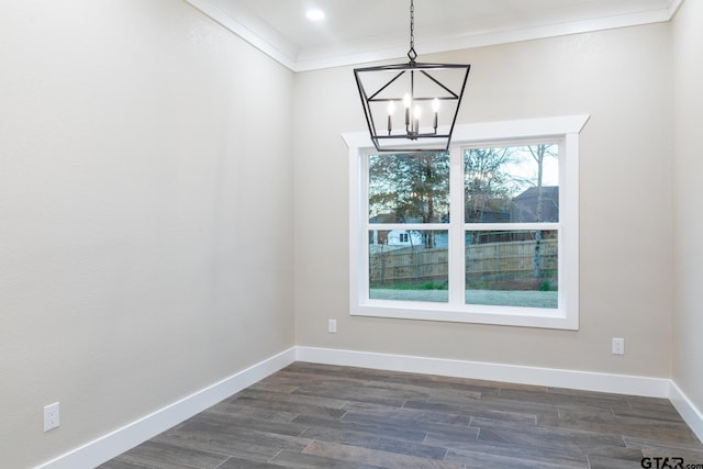 unfurnished dining area with dark hardwood / wood-style floors, a chandelier, and crown molding