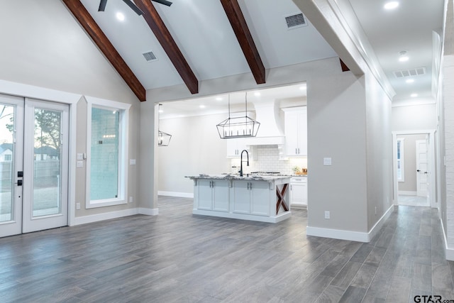 kitchen with dark hardwood / wood-style flooring, white cabinetry, pendant lighting, and an island with sink