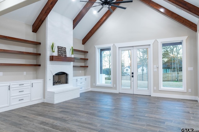 unfurnished living room with dark hardwood / wood-style flooring, beamed ceiling, high vaulted ceiling, and a brick fireplace