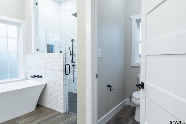 bathroom featuring toilet, hardwood / wood-style flooring, and separate shower and tub