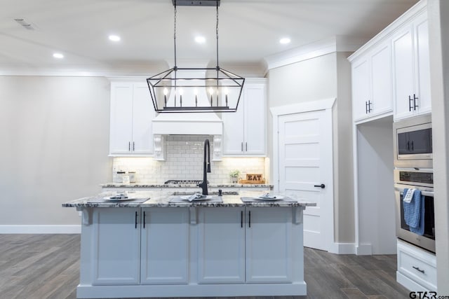 kitchen with white cabinets, stainless steel appliances, dark wood-type flooring, and light stone counters