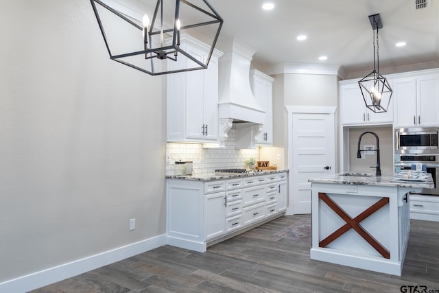 kitchen featuring custom exhaust hood, hanging light fixtures, stainless steel appliances, and white cabinets