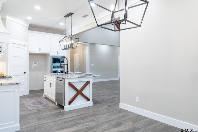 kitchen with a kitchen island with sink, dark hardwood / wood-style flooring, white cabinets, and light stone counters