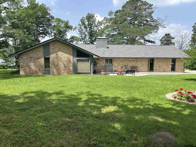 7892 Lakeshore Dr, Tyler, TX 75707 - back of property featuring brick siding, a lawn, and a chimney