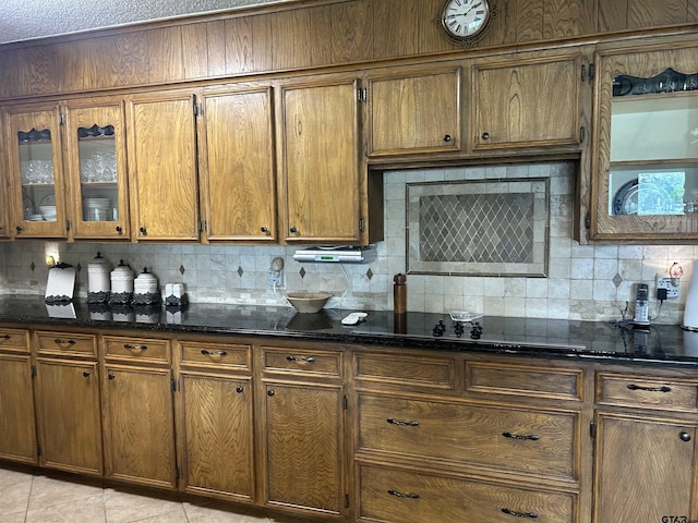 7892 Lakeshore Dr, Tyler, TX 75707 - kitchen with backsplash, brown cabinets, and dark stone countertops