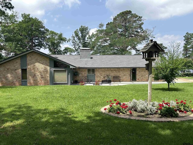 7892 Lakeshore Dr, Tyler, TX 75707 - rear view of property featuring brick siding, a lawn, a chimney, and a shingled roof
