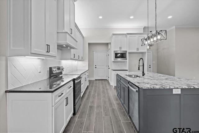 kitchen featuring white cabinetry, sink, appliances with stainless steel finishes, dark wood-type flooring, and pendant lighting