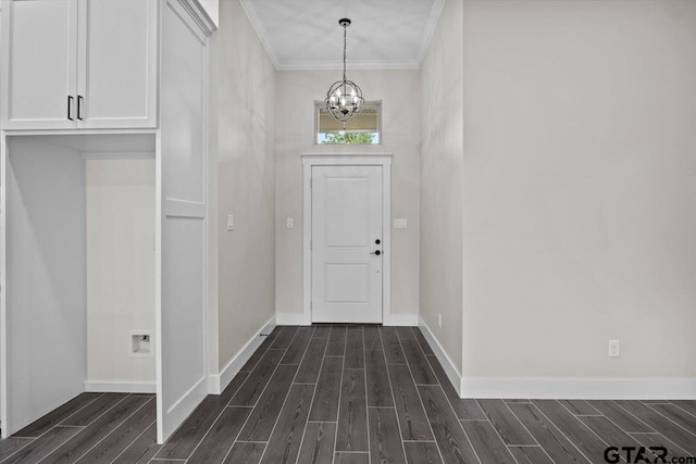 foyer featuring dark wood-type flooring, an inviting chandelier, and crown molding