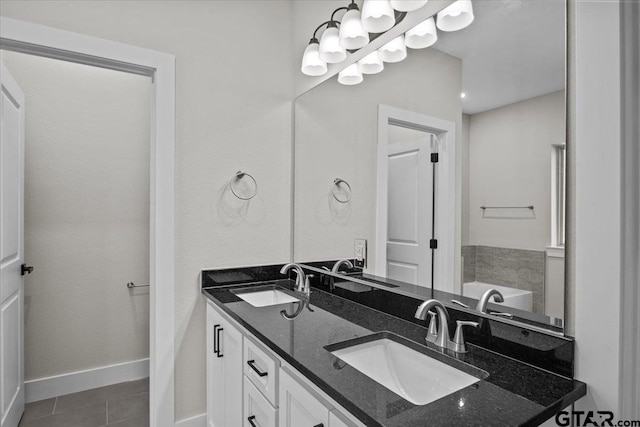 bathroom featuring vanity, tile patterned floors, and a bath