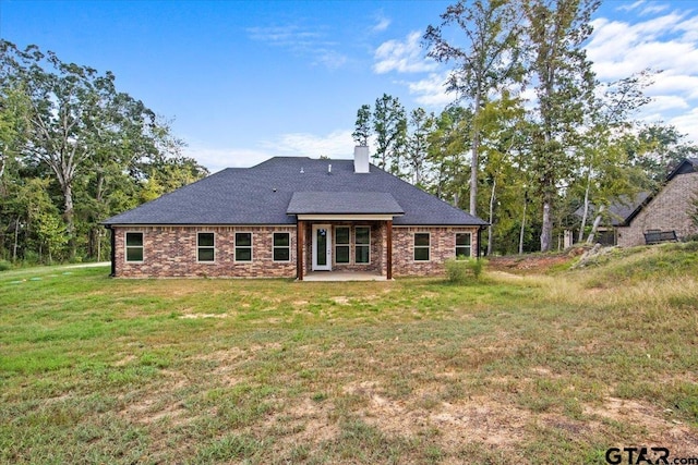 back of house with a lawn and a patio