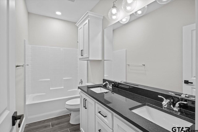 full bathroom with shower / bathing tub combination, wood-type flooring, toilet, and vanity