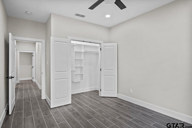 unfurnished bedroom featuring dark wood-type flooring, a closet, and ceiling fan