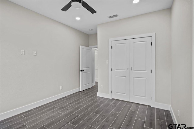 unfurnished bedroom featuring dark hardwood / wood-style flooring, a closet, and ceiling fan