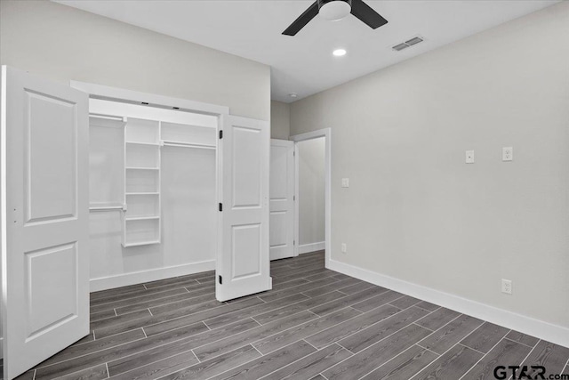 unfurnished bedroom with dark wood-type flooring, a closet, and ceiling fan