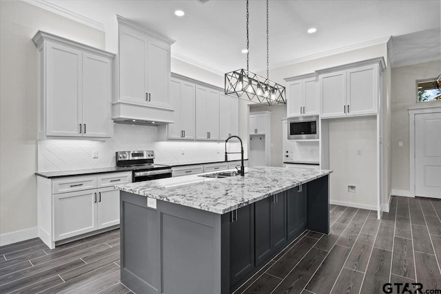 kitchen with stainless steel appliances, a center island with sink, sink, light stone countertops, and decorative light fixtures