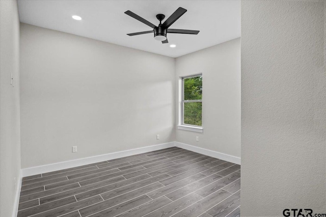 spare room with dark wood-type flooring and ceiling fan