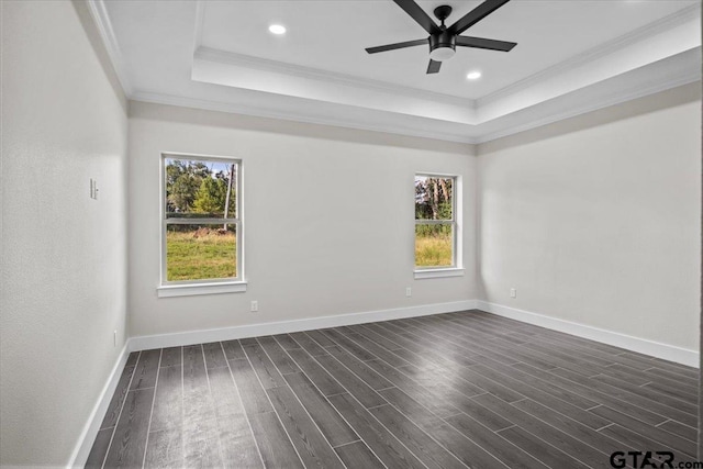 spare room featuring dark hardwood / wood-style flooring, a wealth of natural light, ceiling fan, and crown molding