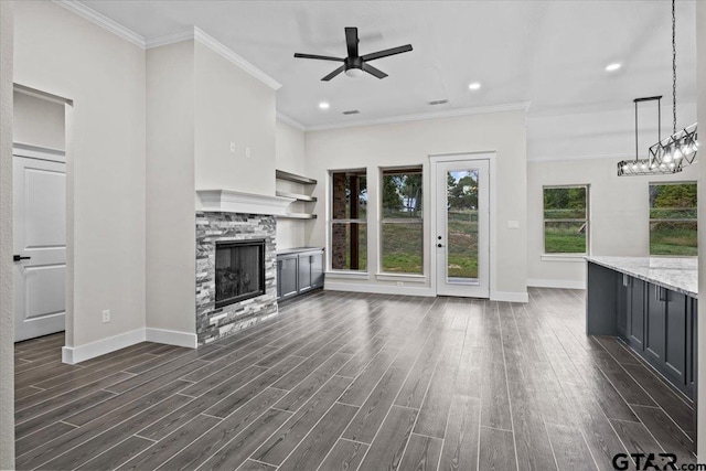 unfurnished living room with a fireplace, dark wood-type flooring, ceiling fan, and crown molding