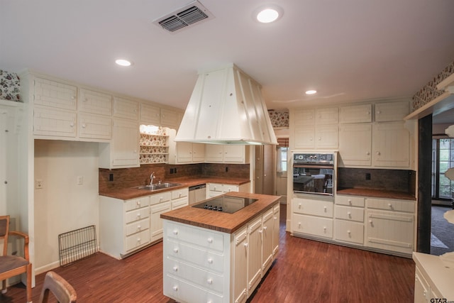 2115 Heather Ln, Tyler, TX 75703 - kitchen with black appliances, premium range hood, a sink, tasteful backsplash, and recessed lighting