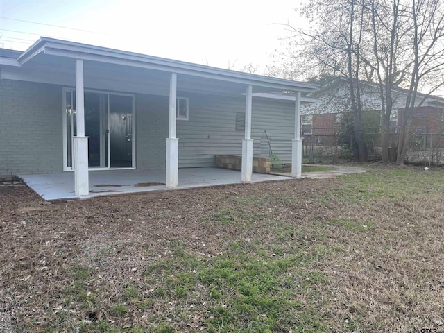 back of house with a patio area and a yard