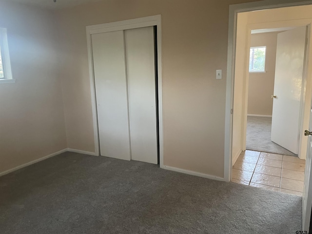 unfurnished bedroom with a closet and light carpet