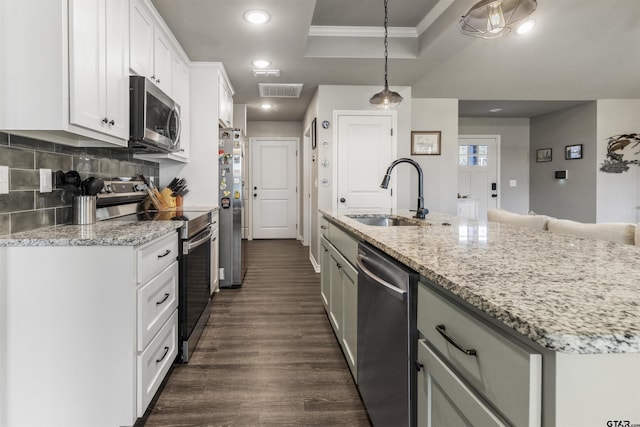 kitchen featuring white cabinetry, sink, an island with sink, pendant lighting, and appliances with stainless steel finishes