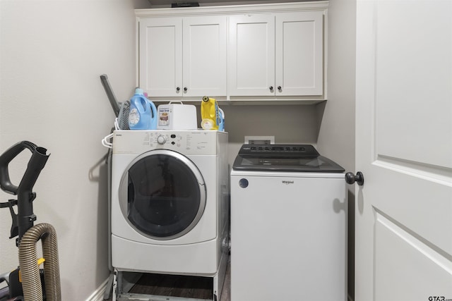 laundry room with separate washer and dryer and cabinets