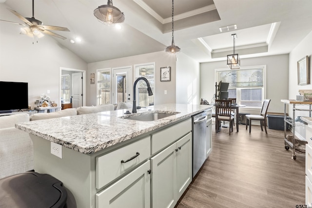 kitchen featuring a raised ceiling, a kitchen island with sink, sink, pendant lighting, and dishwasher