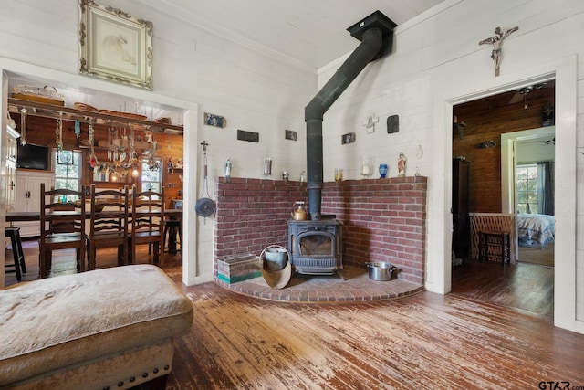 living room with a wood stove, wood walls, and wood-type flooring