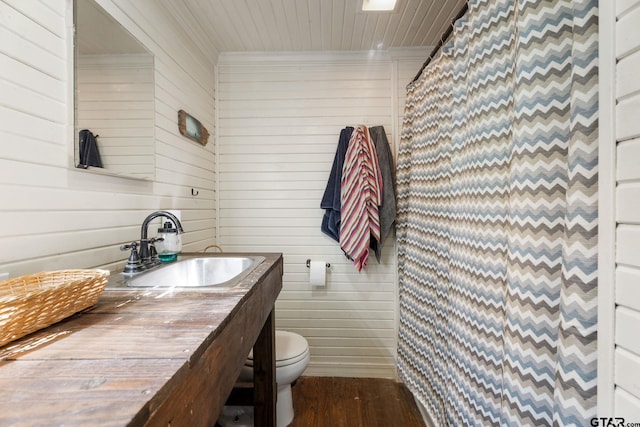 bathroom featuring walk in shower, wooden walls, wood-type flooring, and toilet