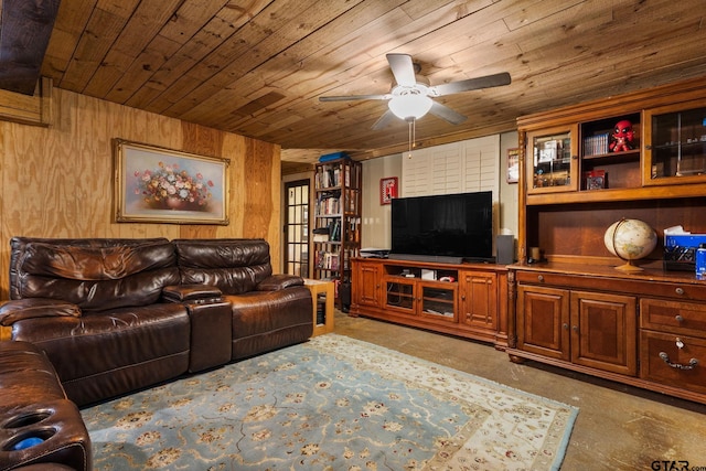 living room featuring ceiling fan, wood ceiling, wooden walls, and concrete floors