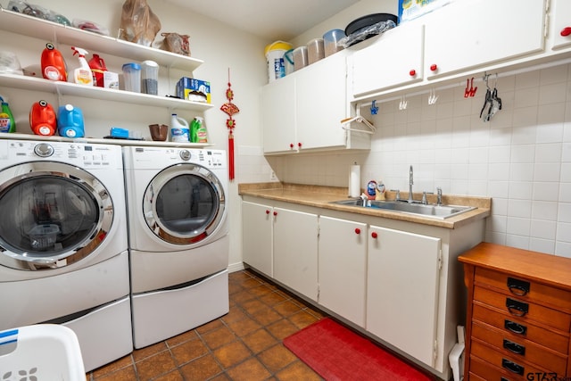 washroom with cabinets, sink, dark tile patterned flooring, and washer and clothes dryer