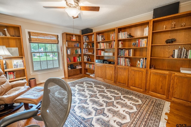 sitting room with crown molding, light hardwood / wood-style flooring, a textured ceiling, and ceiling fan